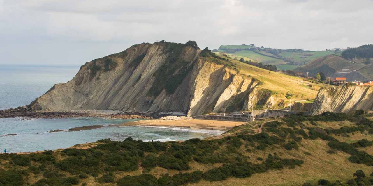 Strand mit darüberliegenden Felsen.